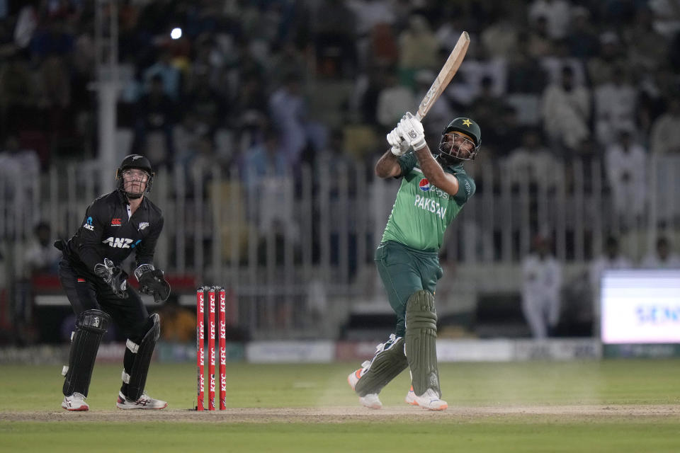 Pakistan's Fakhar Zaman, right, follows the ball after playing a shot for boundary as New Zealand's Tom Latham watches during the first one-day international cricket match between Pakistan and New Zealand, in Rawalpindi, Pakistan, Thursday, April 27, 2023. (AP Photo/Anjum Naveed)