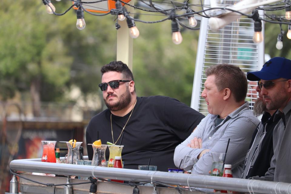 Some tourists watched the activity on the Strip below, leaning over drinks.