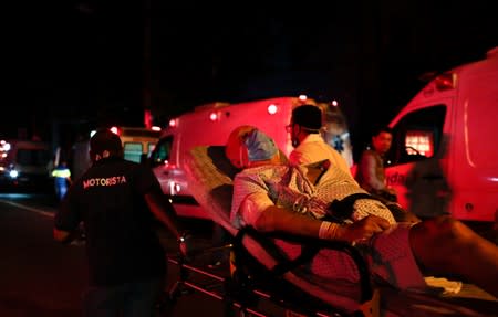 A patient is evacuated after a fire hit the Badim Hospital in Rio de Janeiro, Brazil