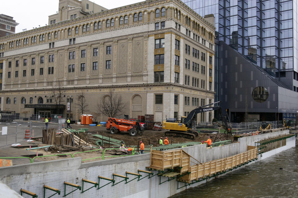 Construction workers are seen working along the river downtown on Jan. 31, 2024, in Grands Rapids, Mich. Michigan will be a key state in determining the outcome of the upcoming 2024 presidential election, with the economy on the minds of many voters in the state. (AP Photo/Kristen Norman)