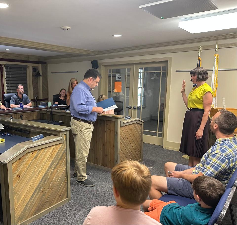 Jessica Purcell’s lawyer, Jeff Levy, swears her onto the Chariho School Committee after her appointment by the Richmond Town Council. Her husband Shawn and two sons watch from the front row.