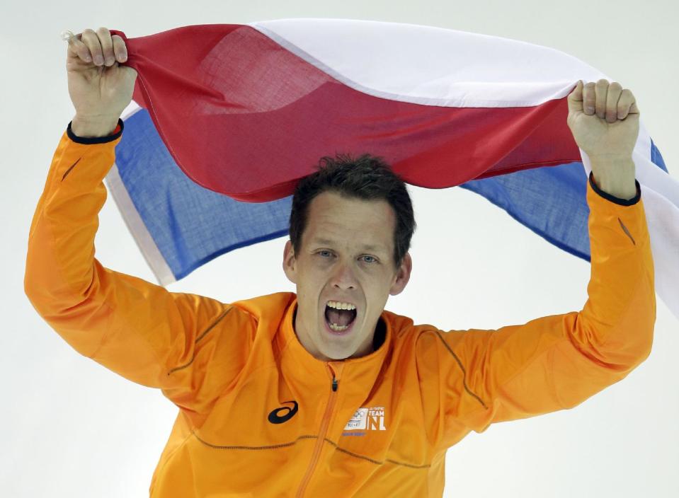 Stefan Groothuis of the Netherlands holds his national flag and celebrates after winning the gold in the men's 1,000-meter speedskating race at the Adler Arena Skating Center at the 2014 Winter Olympics in Sochi, Russia, Wednesday, Feb. 12, 2014. (AP Photo/Patrick Semansky)