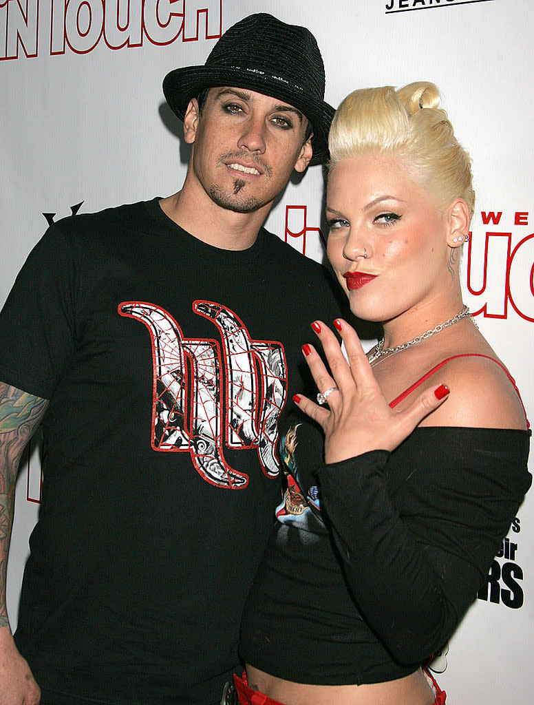 the couple posing together; Carey wears a graphic tee, Pink an off-shoulder top and showing off her engagement ring