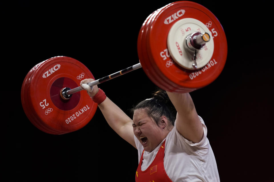 Li Wenwen of China shouts as she completes her final lift to win gold in the women's +87kg weightlifting event at the 2020 Summer Olympics, Monday, Aug. 2, 2021, in Tokyo, Japan. (AP Photo/Seth Wenig)