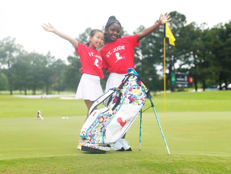 St. Jude patients Maelin-Kate, left, and Azaela, right, pose with their brand-new golf bags during the TaylorMade/PING putt-around on Aug. 8, 2023, at TPC Southwind. The FedEx St. Jude Championship is Aug.10-13 at TPC Southwind.