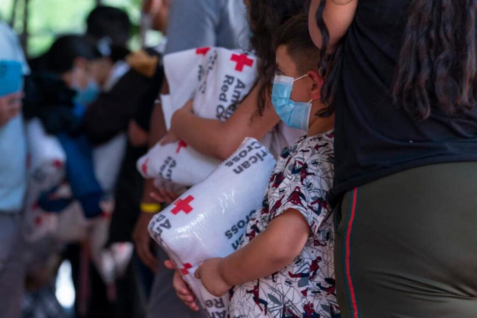 Children who arrived off a bus from Arizona with their families hold blankets from the American Red Cross, as asylum seekers from Latin America and Haiti arrive on a bus sent to Washington from Arizona, Thursday, Aug. 11, 2022, at a church on Capitol Hill in Washington. (AP Photo/Jacquelyn Martin)