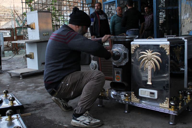 Mohammad Kaweir inspects a heater in Hama