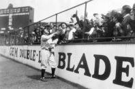 <p>Baseball star Babe Ruth hands out his newly minted candy bars to eager bystanders at Yankee Stadium shortly before the game. </p>