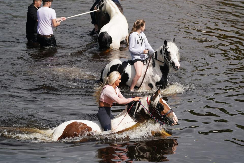 People ride horses in the River Eden, on Day 2 of the Appleby Horse Fair, the annual gathering of gypsies and travellers.