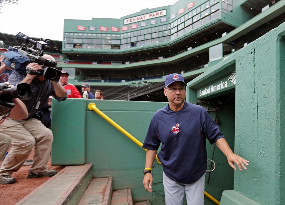 Cleveland manager Terry Francona walks past photographers as he heads to the bench of the visitors' dugout before a game against the Red Sox at Fenway Park.