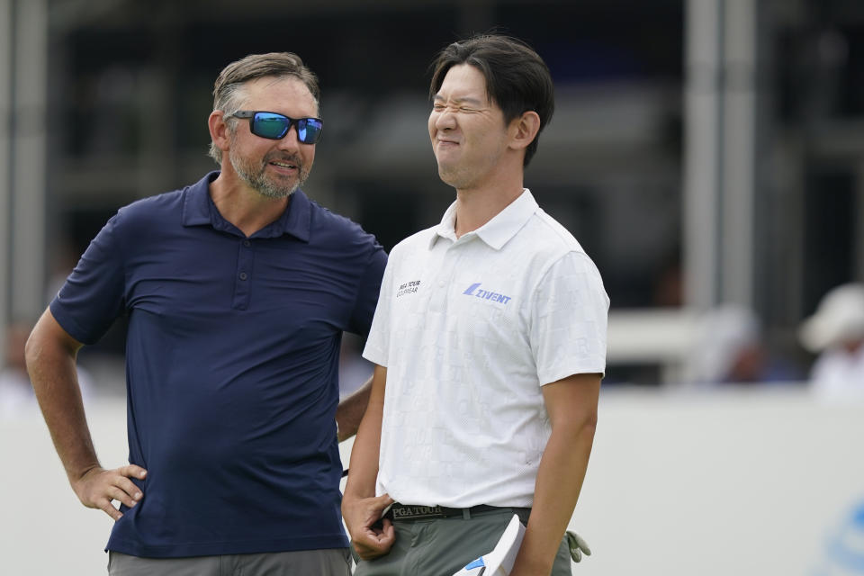 S.Y. Noh, of South Korea, right, reacts to a comment from his caddie Stewart Slover after putting on the 18th hole during the first round of the Byron Nelson golf tournament in McKinney, Texas, Thursday, May 11, 2023. (AP Photo/LM Otero)