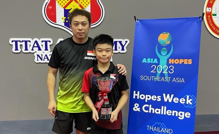 Singapore youth paddler Zane Ong poses with his trophy and coach Wang Yao Jun at the ITTF Regional Hopes Week & Challenge in Bangkok. (PHOTO: STTA)