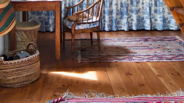 a wall of family photos is the backdrop for the counter area in a barn kitchen with blue and white skirted sink