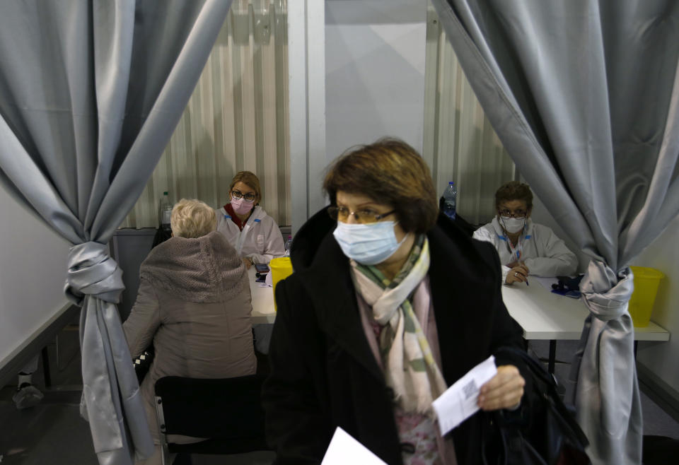 Health workers speak with people at a vaccination center in Belgrade, Serbia, Wednesday, Feb. 17, 2021. Serbia, a country of 7 million, has so far vaccinated some 1 million people, mainly with the Chinese Sinopharm vaccine and Russian Sputnik V, and to a lesser extent with the Pfizer jab. (AP Photo/Darko Vojinovic)