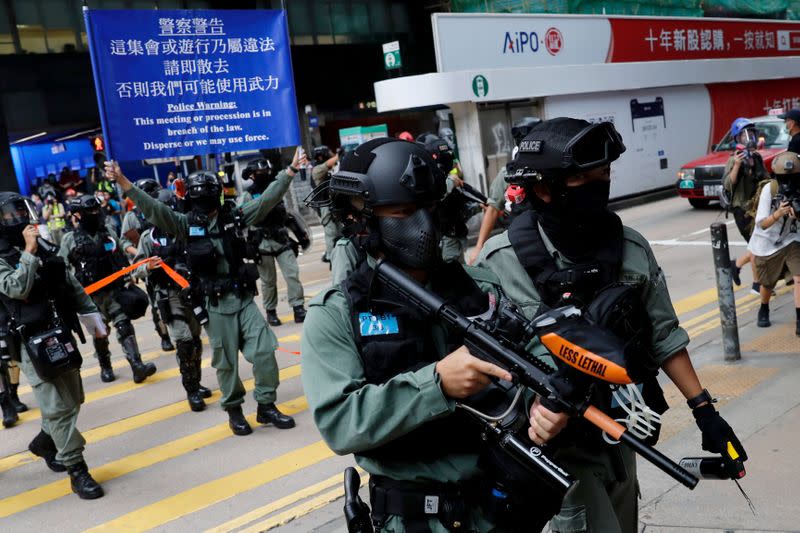 Riot police disperse anti-government demonstrators during a lunch time protest in Central, as a second reading of a controversial national anthem law takes place in Hong Kong