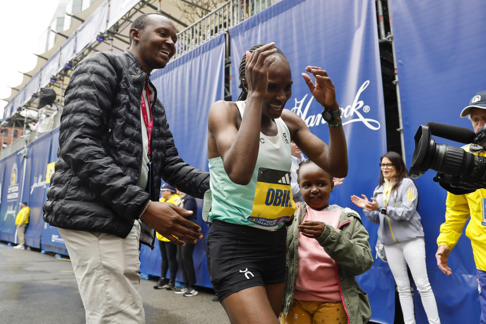Hellen Obiri of Kenya is greeted by her husband Tom Nyaundi and her daughter Tania after winning the women's division of the 127th Boston Marathon Monday, April 17, 2023, in Boston. (AP Photo/Winslow Townson)