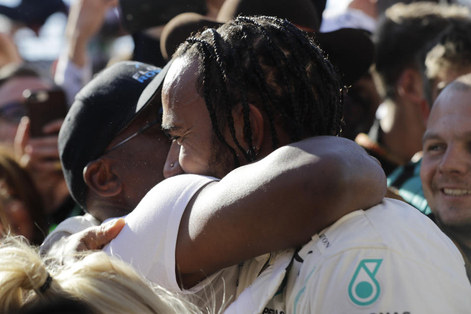 Six-time world champion Mercedes driver Lewis Hamilton, of Britain, hugs his father Anthony Hamilton after the Formula One U.S. Grand Prix auto race at the Circuit of the Americas, Sunday, Nov. 3, 2019, in Austin, Texas. (AP Photo/Darron Cummings)