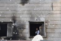 A Free Syrian Army fighter looks out from the window of the burnt Shaar district police station in Aleppo after it was overrun by rebel fighters on July 25. Syrian rebels staved off a fightback by regime forces in Aleppo on Saturday amid growing concern about the risks of reprisals against civilians in the country's commercial capital