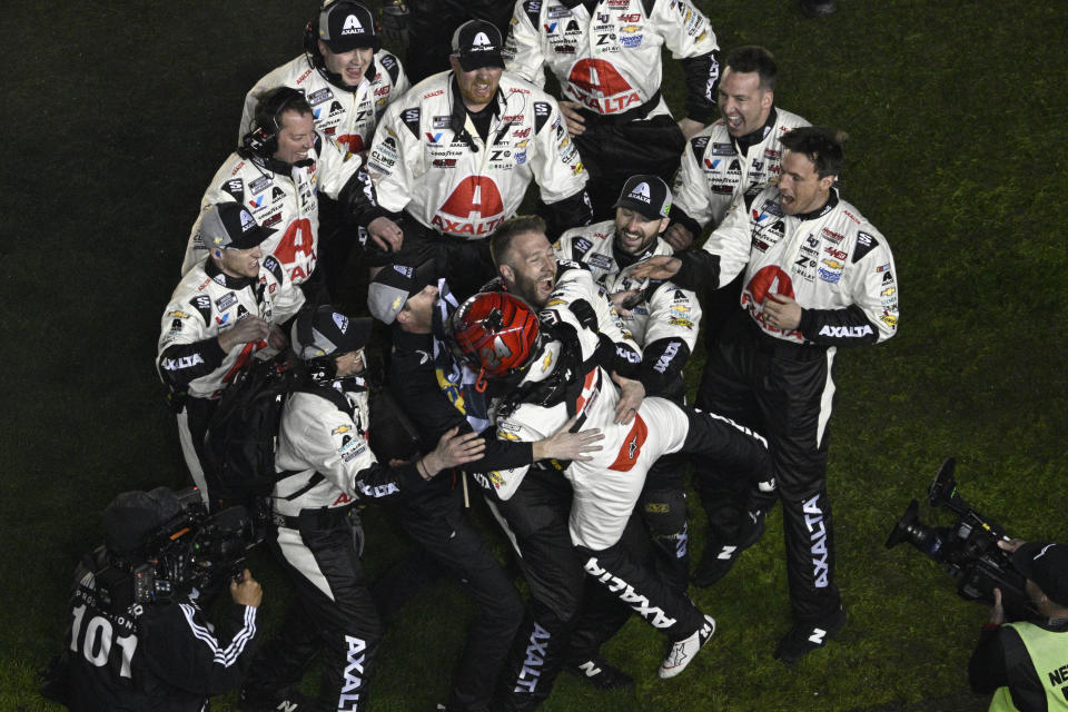 William Byron, cottom center, celebrates with his crew members on the infield grass after winning the NASCAR Daytona 500 auto race at Daytona International Speedway, Monday, Feb. 19, 2024, in Daytona Beach, Fla. (AP Photo/Phelan M. Ebenhack)