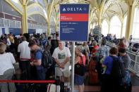 Passengers wait in line to check in after Delta Air Lines computer systems crashed leaving passengers stranded at airports around the globe as flights were grounded at Ronald Reagan Washington National Airport in Washington, U.S., August 8, 2016. REUTERS/Joshua Roberts