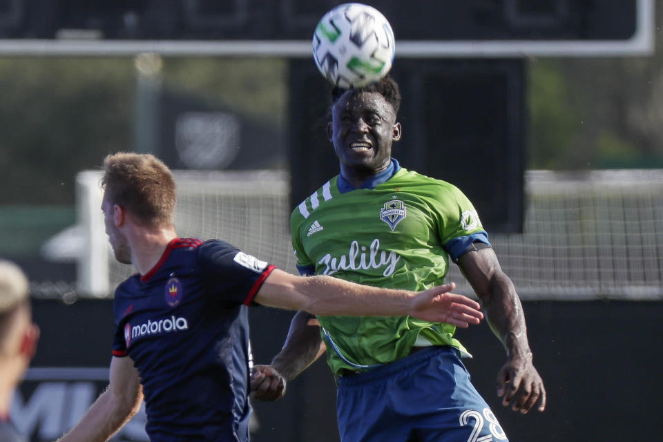 Chicago Fire forward Robert Beric, left, battles with Seattle Sounders defender Yeimar Gomez for possession of the ball during the first half of an MLS soccer match, Tuesday, July 14, 2020, in Kissimmee, Fla. (AP Photo/John Raoux)