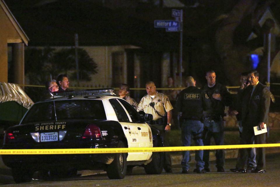 Los Angeles County Sheriff's deputies and investigators stand near the scene where a pedestrian was killed in a hit-and-run crash reportedly involving rap mogul Marion "Suge" Knight, in Compton, California