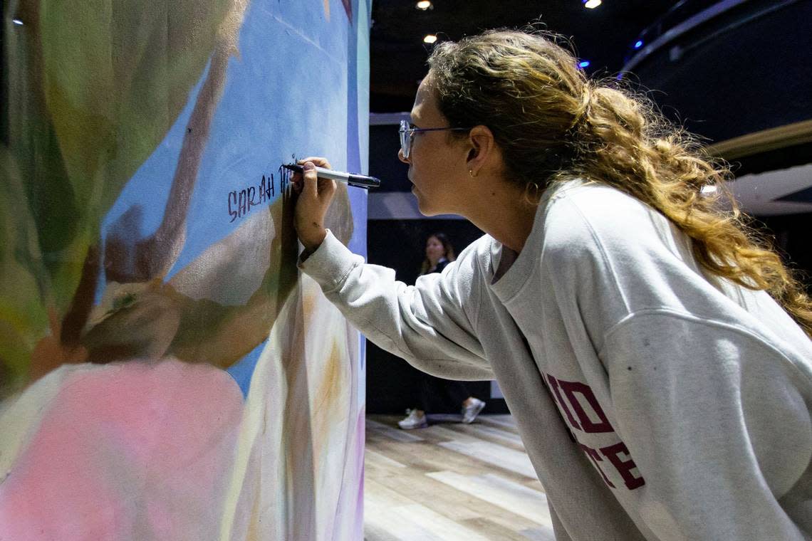 Sarah Painter signs a mural at the front set up at the entrance of The Moon a few hours before Vice President Kamala Harris speaks in Tallahassee, Florida in honor of the 50th anniversary of Roe v. Wade on Sunday Jan. 22, 2023.