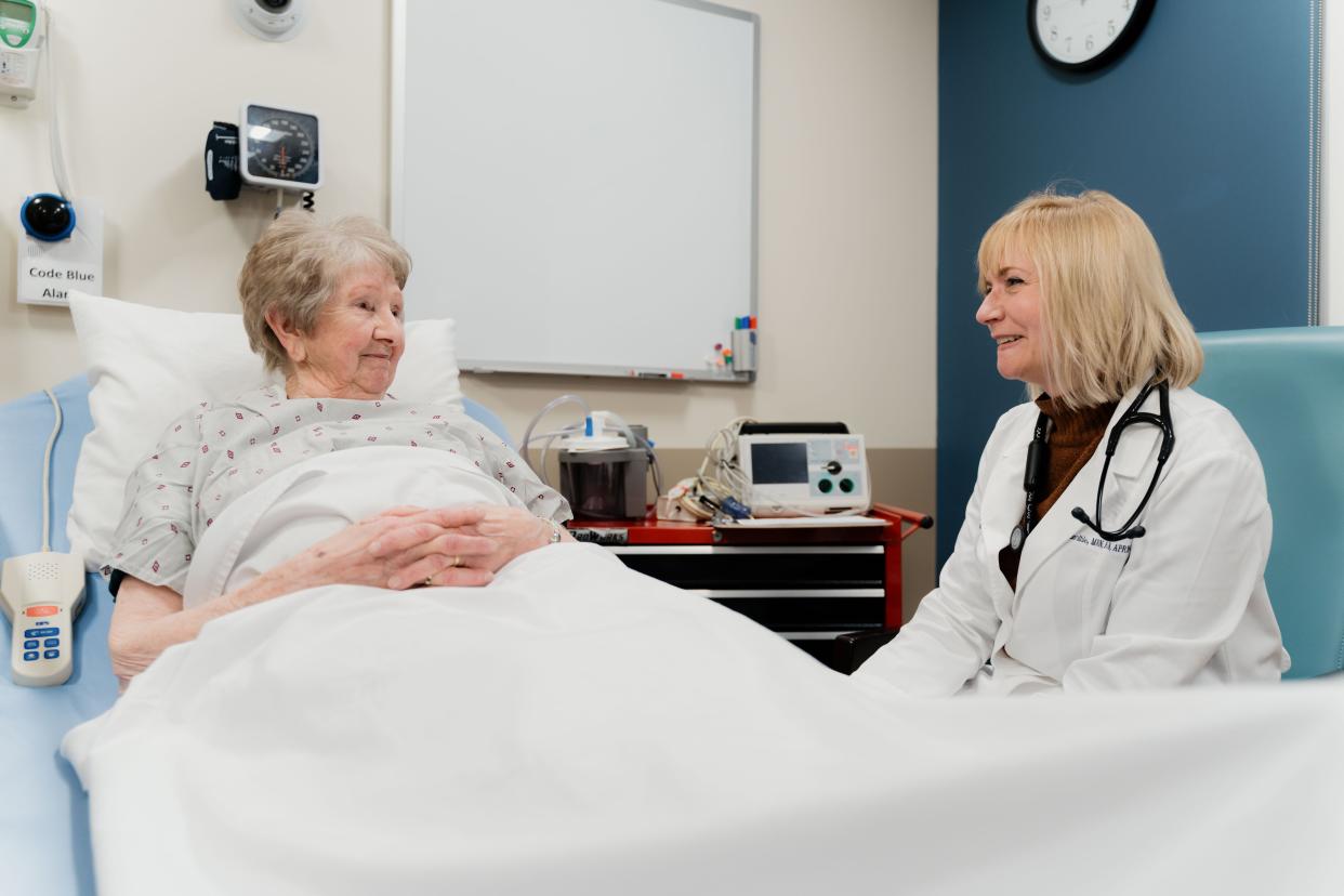 Pamela Barthle (right), Augustana University assistant professor of nursing, who has practiced nursing for 36 years and is an AG-ACNP in cardiology at Sanford Health in Sioux Falls, works with a patient at Sanford.