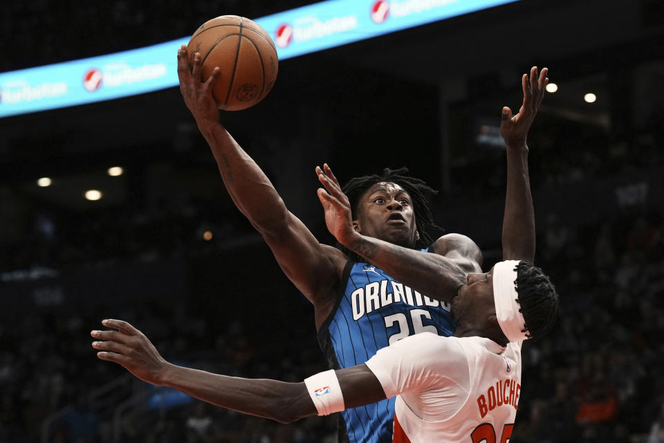 Toronto Raptors' Chris Boucher receives a blow to the mouth from Orlando Magic's Admiral Schofield's elbow during the second half of an NBA basketball game, Saturday, Dec. 3, 2022 in Toronto. (Chris Young/The Canadian Press via AP)