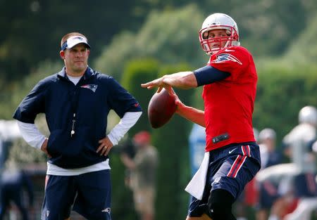 Jul 30, 2015; Foxborough, MA, USA; New England Patriots quarterback Tom Brady (12) throws as offensive coordinator Josh McDaniels looks on during training camp at Gillette Stadium. Mandatory Credit: Winslow Townson-USA TODAY Sports