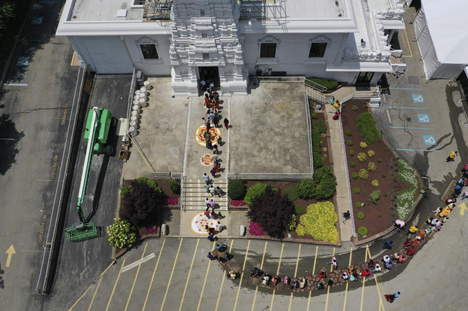 Devotees line up to enter the Sri Venkateswara Temple following the final rituals of Maha Kumbhabhishekam, the Hindu rededication ceremony in Penn Hills, Pa., Sunday, June 27, 2021. Built in the 1970s, Built in the 1970s, the Sri Venkateswara Temple is the oldest major Hindu temple in the country. Maha Kumbhabhishekams occur about every 12 years and involve ceremonies to reenergize the temple and its deities. (AP Photo/Jessie Wardarski)