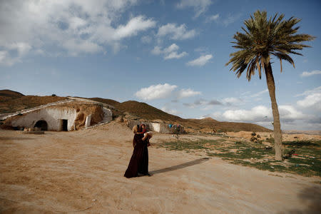 Saliha Mohamedi, 36, walks outside her troglodyte house on the outskirts of Matmata, Tunisia, February 4, 2018. REUTERS/Zohra Bensemra