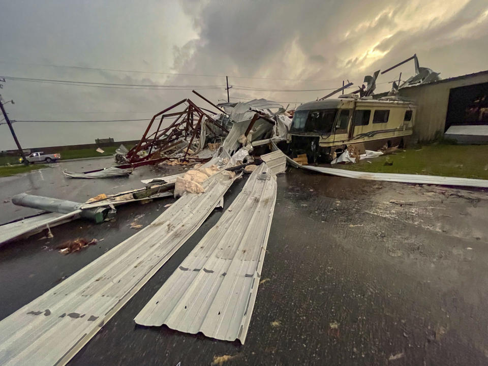 A recreational vehicle is damaged from severe weather next to a collapsed building on N. Peters Street in Arabi, La., in St. Bernard Parish Wednesday, Dec. 14, 2022. (AP Photo/Matthew Hinton)