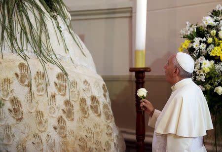 Pope Francis prays in front of the Virgin Mary statue at Caacupe church in Caacupe, outside of Asuncion, Paraguay, July 11, 2015. REUTERS/Alessandro Bianchi