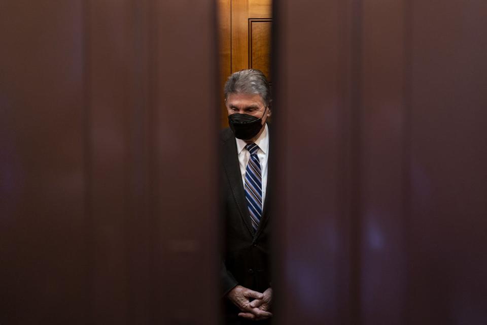 Sen. Joe Manchin of West Virginia stands behind closing doors.