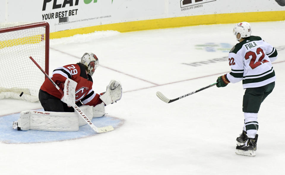 Minnesota Wild left wing Kevin Fiala (22) scores a goal against New Jersey Devils goaltender Mackenzie Blackwood (29) in a shootout during an NHL hockey game Wednesday, Nov.24, 2021, in Newark, N.J. The Wild defeated the Devils 3-2 in a shootout. (AP Photo/Bill Kostroun)