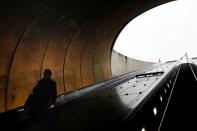 FILE PHOTO: A person descends down an escalator during commuter evening rush hour, at the Dupont Circle Metro underground train station, as Mayor Muriel Bowser declared a State of Emergency due to the coronavirus disease (COVID-19) in Washington