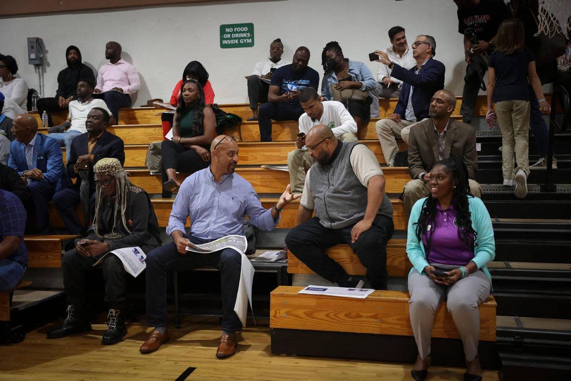 People flip through the pamphlet provided by the county during Monday’s town hall discussing the potentials for the Poinciana Industrial Park at the Gwen Cherry Park gymnasium.