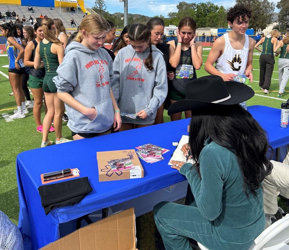 Agoura High graduate and Olympic track athlete Tara Davis signs autographs during the first annual Tara Davis Invitational at Agoura High on Saturday, Feb. 24, 2024.