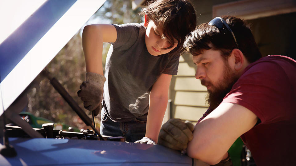 Father teaching son to work on a truck.