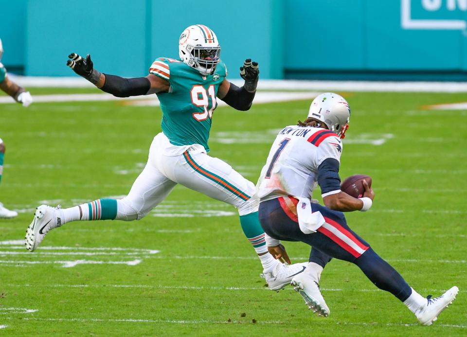 Miami Dolphins defensive end Emmanuel Ogbah (91) pursues New England Patriots quarterback Cam Newton (1) in the third quarter at Hard Rock Stadium in Miami Gardens, December 20, 2020.