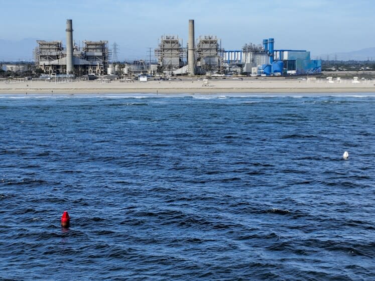 Huntington Beach, CA - April 5: Two buoys mark the location of intake and outflow pipes currently used by the AES Huntington Beach Energy Center, and is the proposed site of the Poseidon Desalination Plant, which would draw ocean water through the existing intake pipe. In the background is neighboring residential community, Edison Community Park, Edison High School, ASCON toxic State superfund cleanup site, the proposed Magnolia Tank Farm Lodge, restaurants, and retail, upper right, the Huntington Beach Wetlands, middle right, and Huntington State Beach. Photo taken Tuesday, April 5, 2022. The partially retired Huntington Beach Generating Station consists of four generating units but only unit 2 is still in commercial operation as a legacy unit and has an extension to operate through the end of 2023, issued by the California State Water Boards. Unit 2 runs to support peak demands and has a net output capacity of 225 megawatts. The 644 MW combined cycle gas turbine generator, shown in blue and white, began operation on June 25, 2020. Environmental groups have fought Poseidon, arguing that it is privatizing a public resource, has failed to adapt an old proposal to new state ocean protections from killing sea life and that the company is trying to fill a need that doesn't exist, uses too much natural gas energy. Environmental justice activists say water rates could be raised as much as $6 per month. Supporters say ocean desalination as an inexhaustible, local supply for a region that imports much of its water from increasingly unreliable, distant sources. Another stumbling block for Poseidon is state requirements to mitigate the project's harm to the marine environment. Poseidon would draw 106 million gallons a day of seawater through the huge offshore intake pipe, which would be screened, and use reverse osmosis membranes to rid the seawater of salt and impurities. That process would produce 56 million gallons a day of brine concentrate - roughly twice as salty as the ocean - which would be dumped back into the Pacific via a 1,500-foot discharge pipe equipped with outfall diffusers to promote mixing and dilution. The intake and discharge operations will take a toll on plankton, which plays a crucial role in the marine food chain, killing an estimated 300,000 microscopic organisms a day. (Allen J. Schaben / Los Angeles Times)
