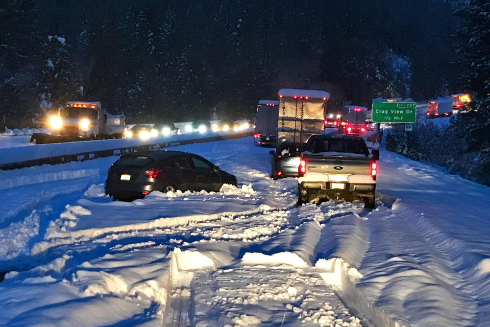 In this photo taken Tuesday, Nov. 26, 2019, provided by Caltrans, are cars and trucks in stopped traffic on Interstate 5 near Dunsmuir, Calif. A "bomb cyclone," which triggers a rapid drop in air pressure, brought snow to the mountains and wind and rain along the California and Oregon coasts. Drivers on Interstate 5 near the Oregon-California border spent 17 hours or more in stopped traffic as blizzard conditions whirled outside. Some slept in their vehicles. (Caltrans via AP)