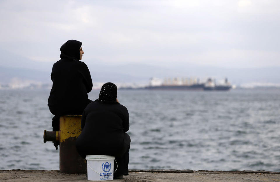 <p>Two women sit on a dock of a refugee camp which houses about 3,200 refugees and migrants, in the western Athens’ suburb of Skaramagas, Aug. 25, 2016. Numbers arriving in Greece have dropped dramatically since the March agreement with Turkey, but over 58,000 people remain stranded in the country, most in army-built camps on the mainland and over 9,000 refugees are receiving hotel vouchers or live in vacant apartments. (Photo: Thanassis Stavrakis/AP)</p>