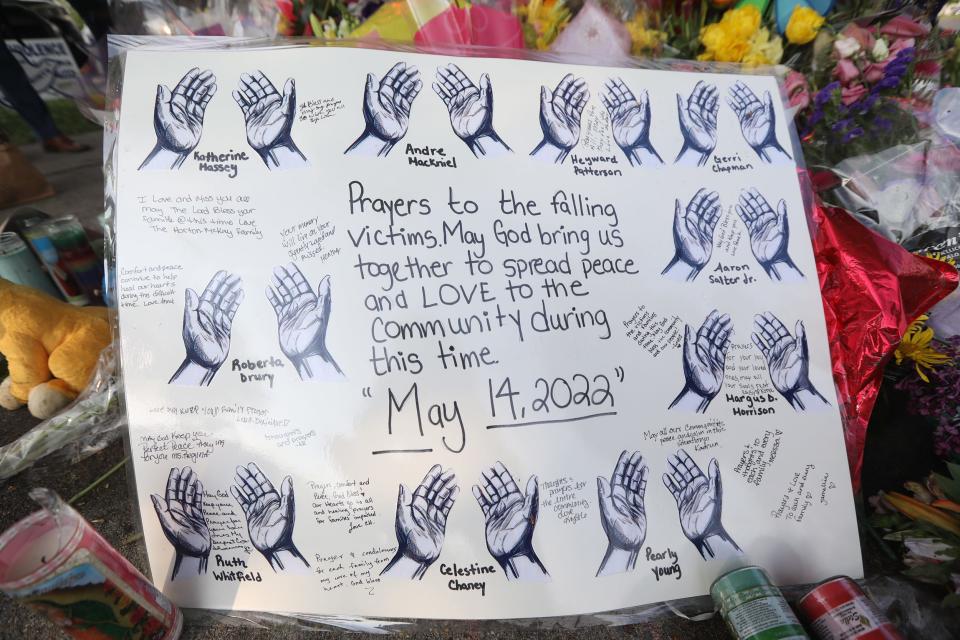 A sign with hands around each person's name who died in the mass shooting was left across from the Tops Friendly Market on Jefferson Ave. in Buffalo, NY with a message on May 16, 2022 