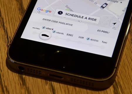 A photo illustration shows the Uber app logo displayed on a mobile telephone, as it is held up for a posed photograph in central London, Britain October 28, 2016. REUTERS/Toby Melville/Illustration