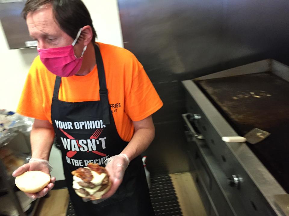 Bri's Fries owner Brian Billings prepares a burger at the Milton restaurant Jan. 26, 2021.