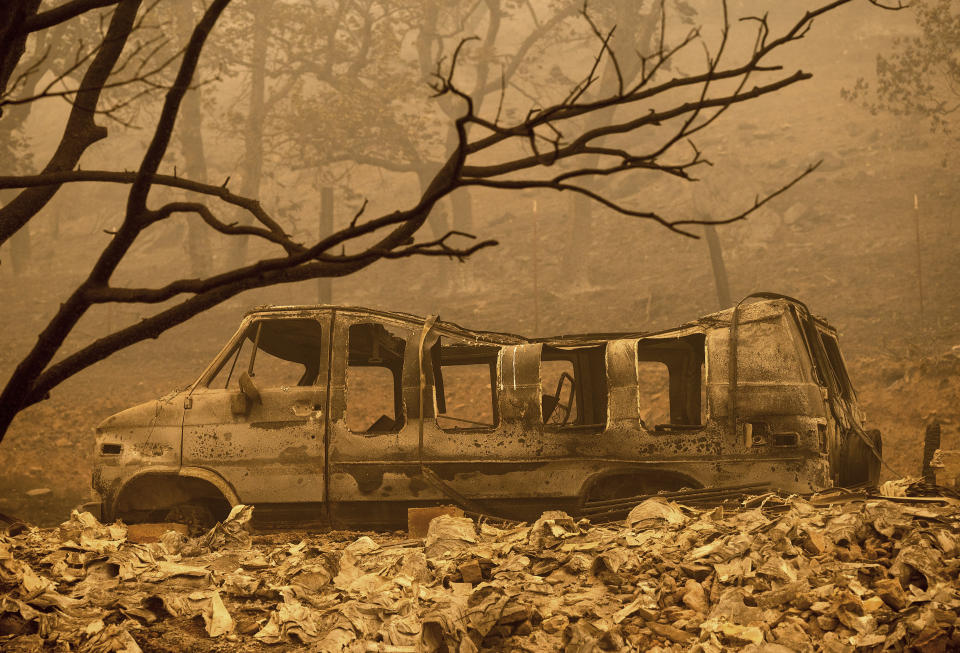 A scorched van sits in a clearing as the McKinney Fire burns in Klamath National Forest, Calif., on Sunday, July 31, 2022. (AP Photo/Noah Berger)