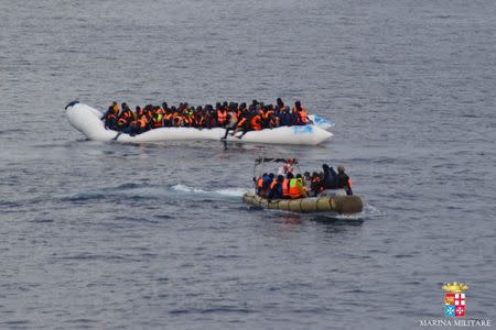 Migrants sit in their boat during a rescue operation of 219 migrants by Italian naval vessel Bettica (not seen) in this February 23, 2016 handout picture provided by Marina Militare. REUTERS/Marina Militare/Handout via Reuters