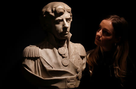A member of Sotheby's staff poses for a photograph with a marble bust of Lord Nelson union which forms part of a sale of items called Nelson's Legend, in London, Britain January 11, 2018. REUTERS/Peter Nicholls